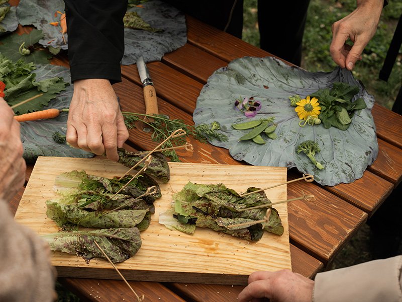 Participants of “Zukunft aufgetischt!” arranging salad and edible flowers.