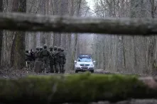 Polizeiauto und eine Gruppe von Grenzbeamten im Wald zwischen Belarus und Polen