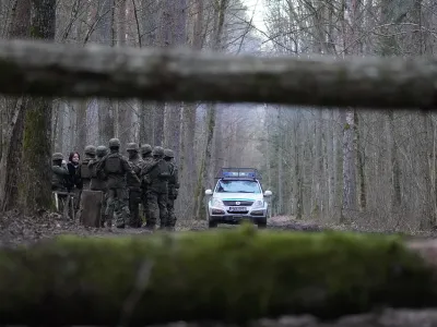Polizeiauto und eine Gruppe von Grenzbeamten im Wald zwischen Belarus und Polen