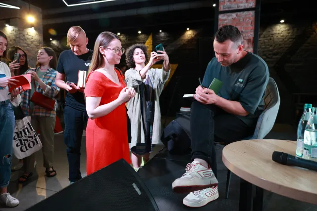 Der Schriftsteller Artem Tschech gibt Autogramme beim Meridian Literaturforum in Saporischschja im Juni 2026