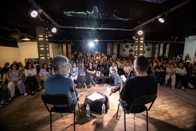 Die Schriftsteller Oleksandr Bojtschenko und der Schriftsteller Artem Tschech lesen auf einer Bühne beim Literaturforum Meridian in Charkiw im Juni 2026