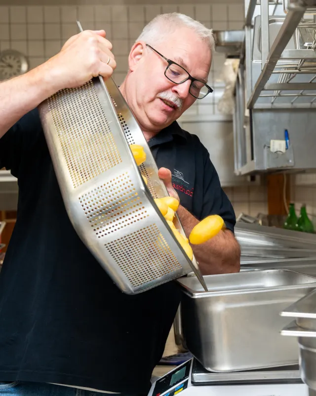 Der Caterer Hermann Heitmann aus dem norddeutschen Verden schüttet Kartoffeln in ein Sieb