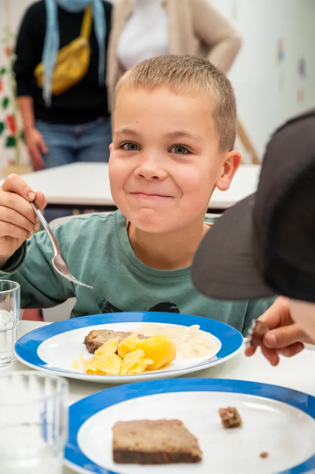 Junge am Tisch in einer Schulkantine