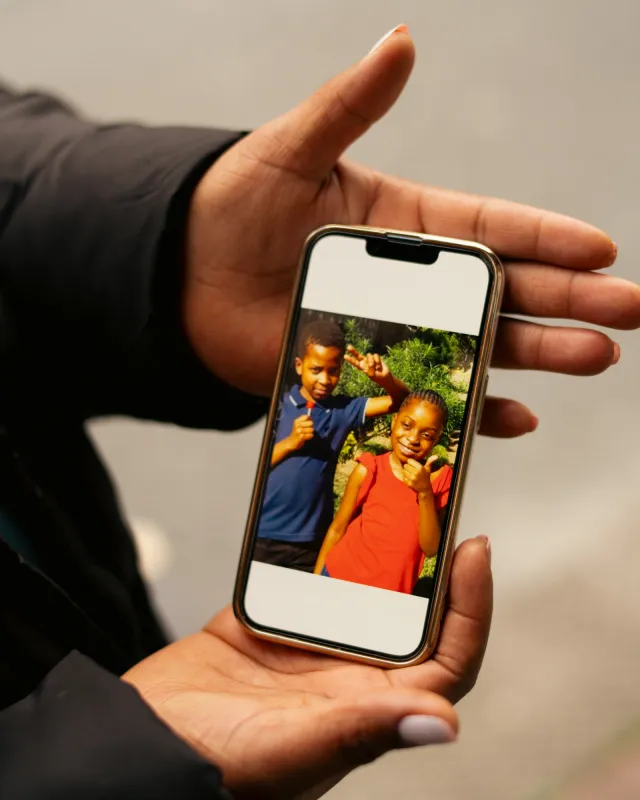 Arbeitsmigrantin zeigt Foto ihrer Kinder