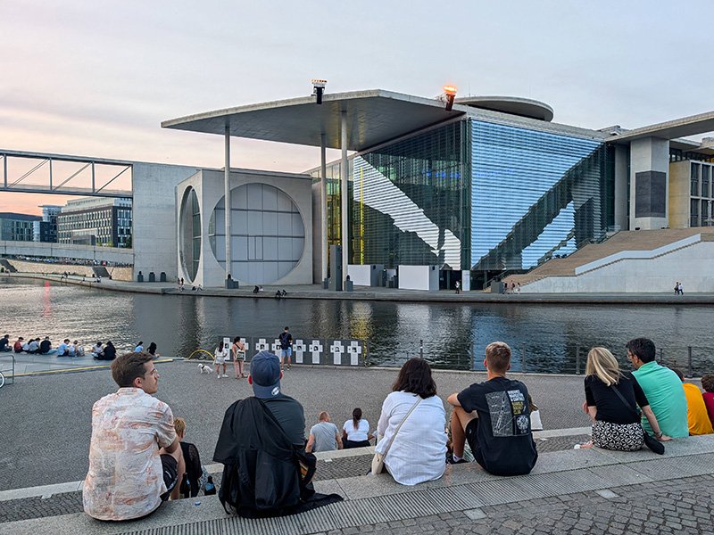 Bürger:innen sitzen auf einer Treppe im Berliner Regierungsviertel